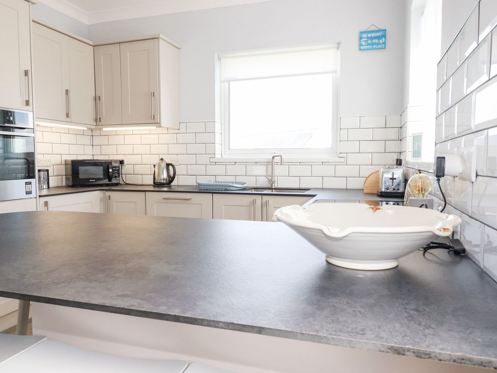 A kitchen with cabinets and appliances at 22 Pentire Avenue in Newquay