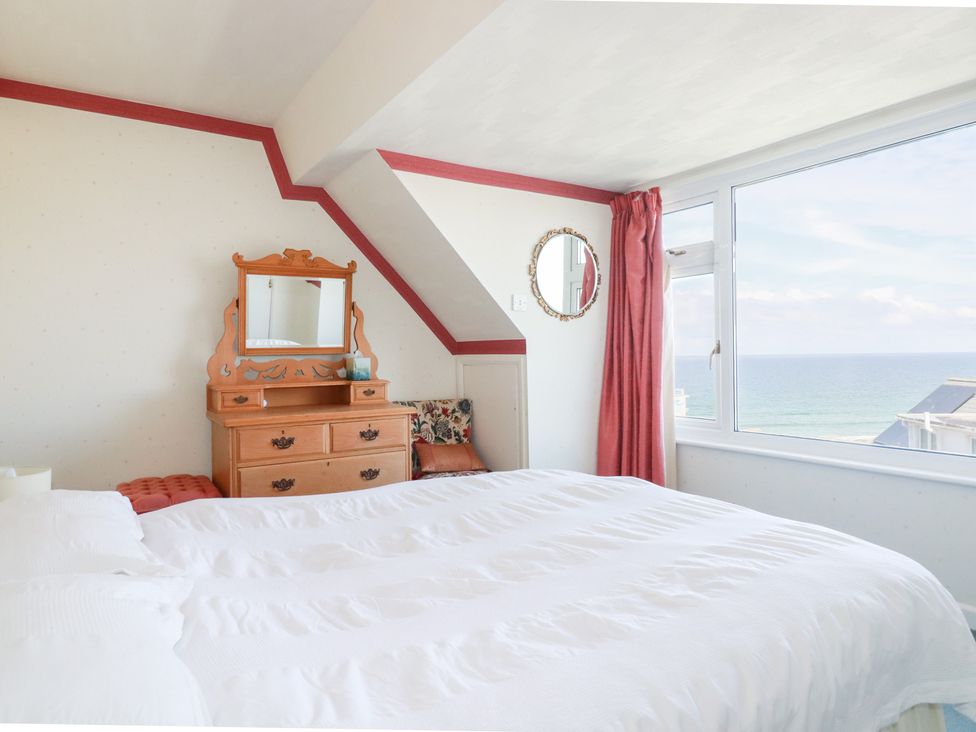 A bedroom with a bed and dresser at 22 Pentire Avenue Newquay