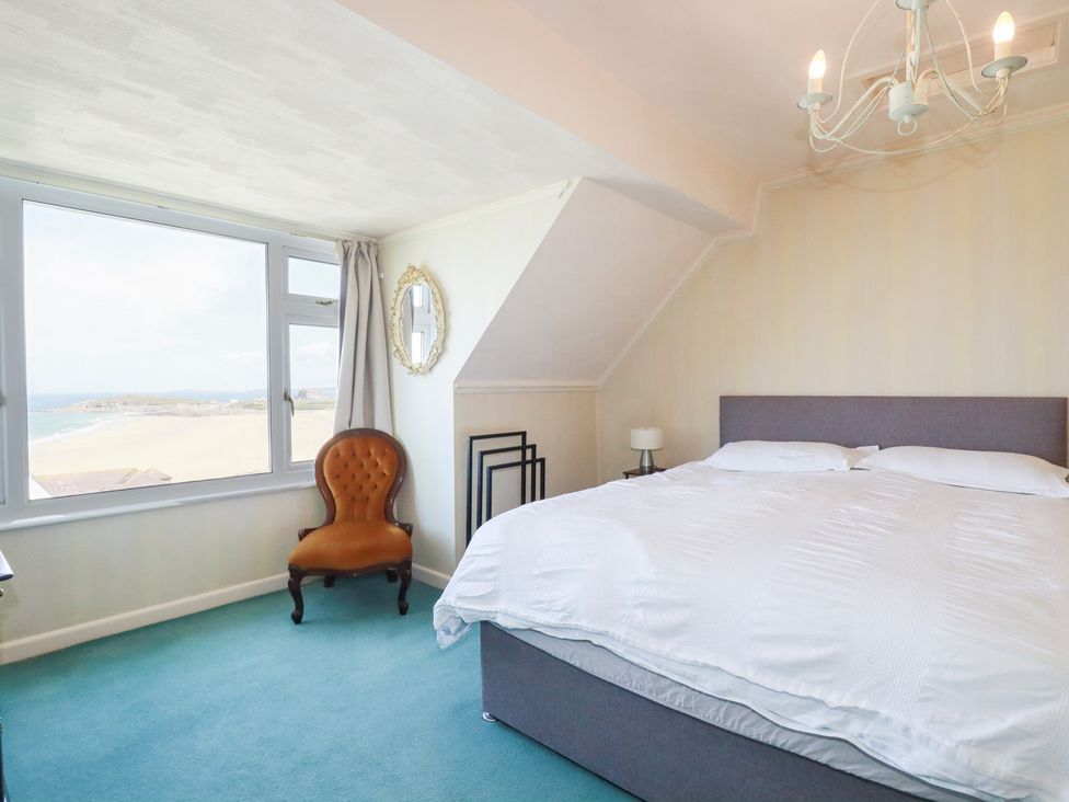 A bedroom with a bed and a chair at 22 Pentire Avenue Newquay