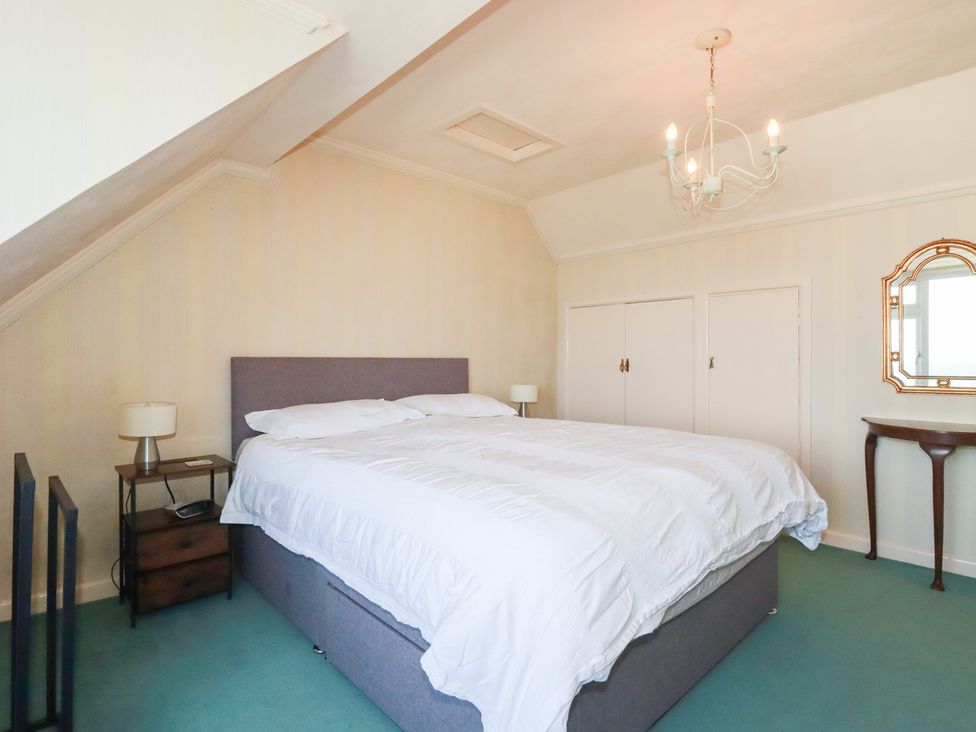 A bedroom with a bed and nightstand at 22 Pentire Avenue in Newquay