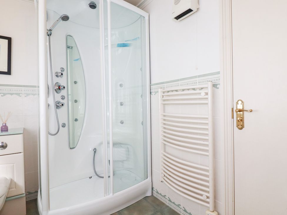 A bathroom with a shower and radiator at 22 Pentire Avenue in Newquay