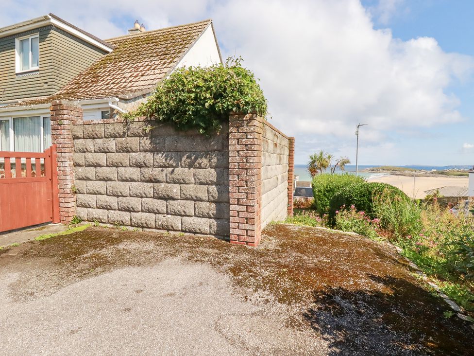 An outdoor view of a house with a wall and gate at 22 Pentire Avenue Newquay