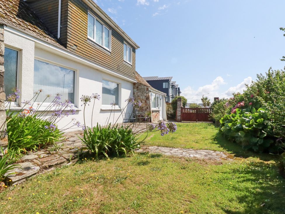 A garden area with flowers and a house at 22 Pentire Avenue Newquay