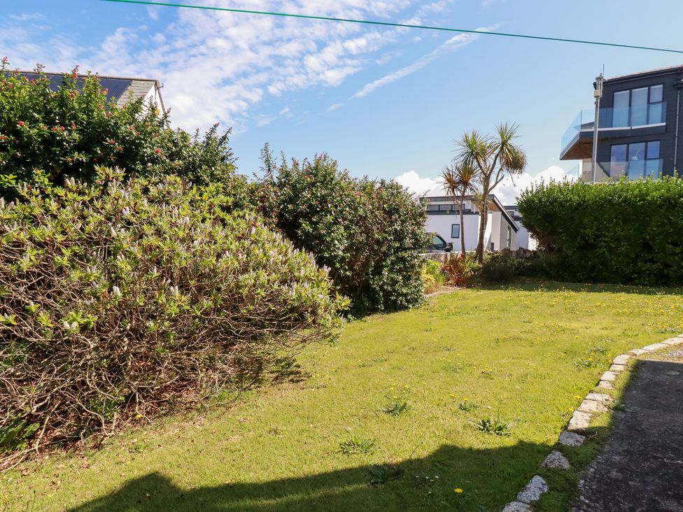 A garden with grass and bushes at 22 Pentire Avenue in Newquay