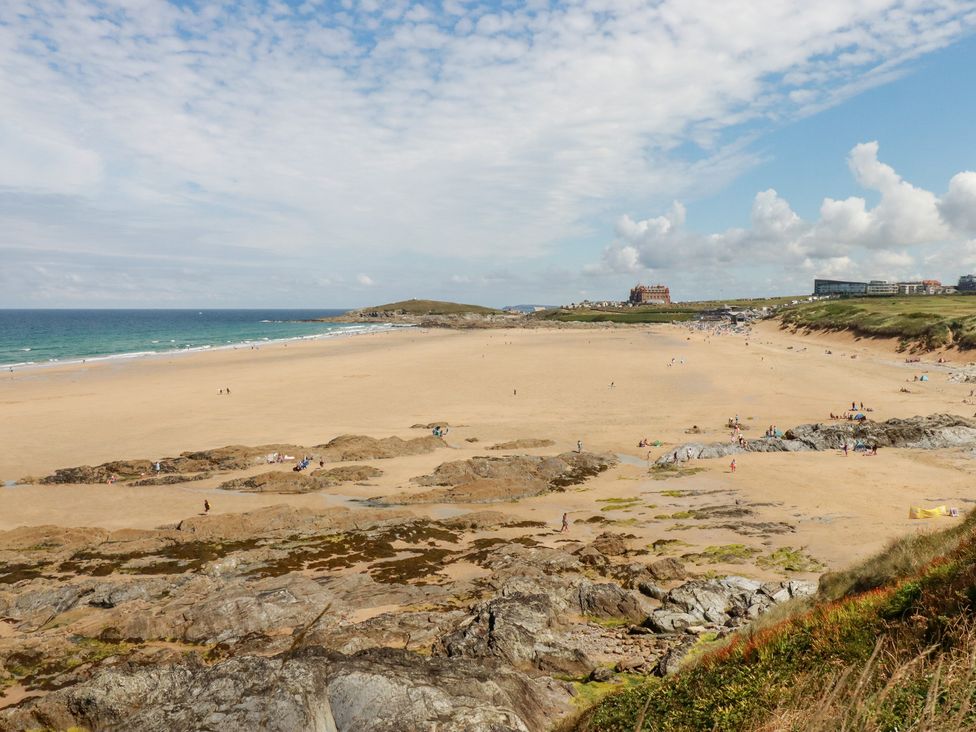 A beach scene with people and rocks at 22 Pentire Avenue Newquay