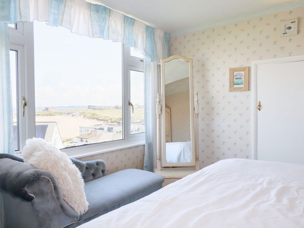 A bedroom with a window and mirror at 22 Pentire Avenue Newquay