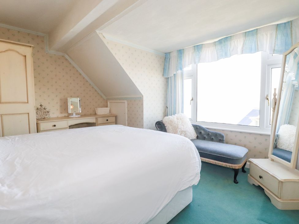 A bedroom with a bed, mirror, and dressing table at 22 Pentire Avenue Newquay