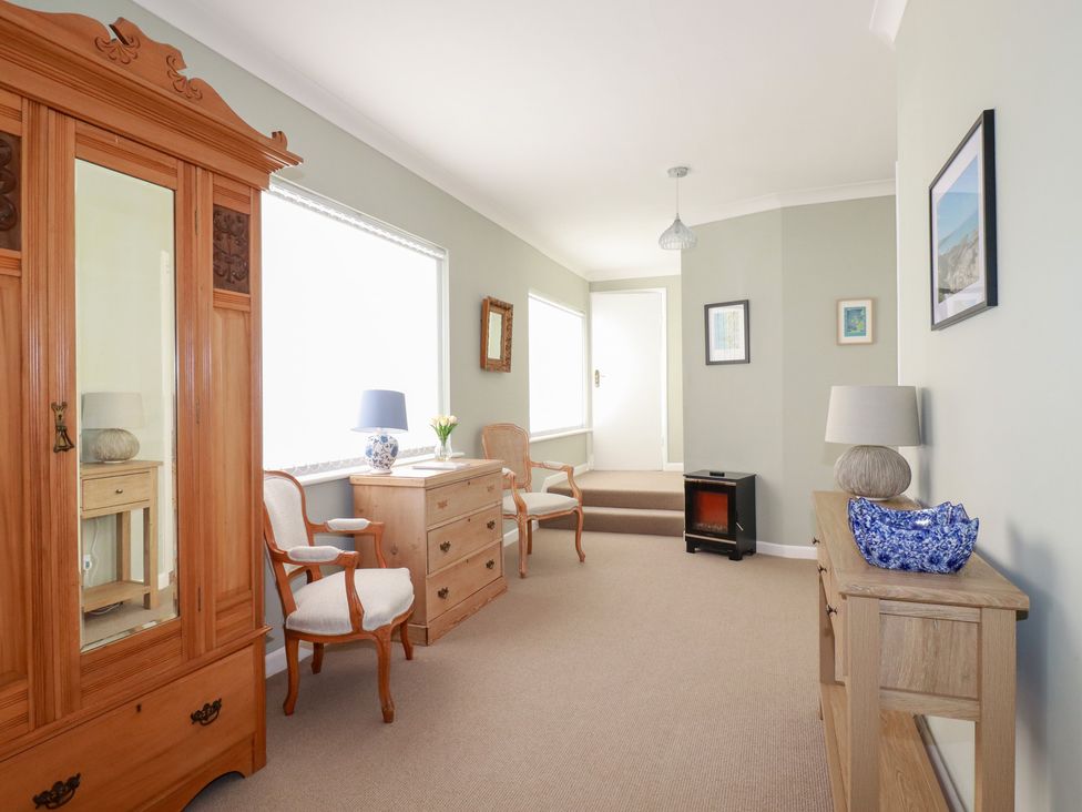 A hallway with a wardrobe and chairs at Pipers in Newquay