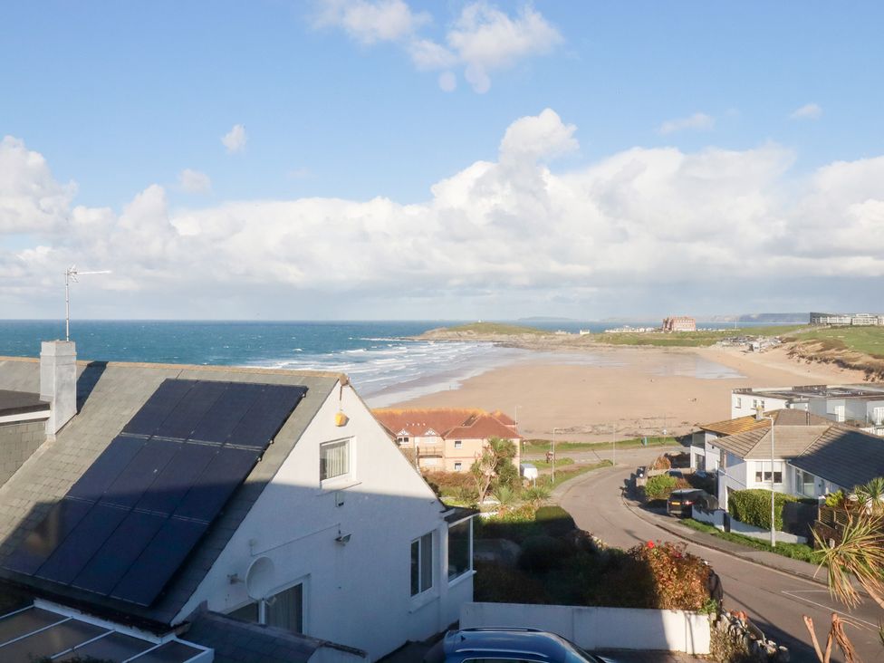 A beach view with ocean and houses at Pipers in Newquay
