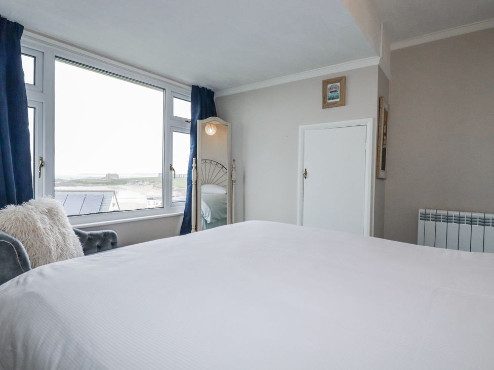 A bedroom with a bed and windows at Pipers in Newquay
