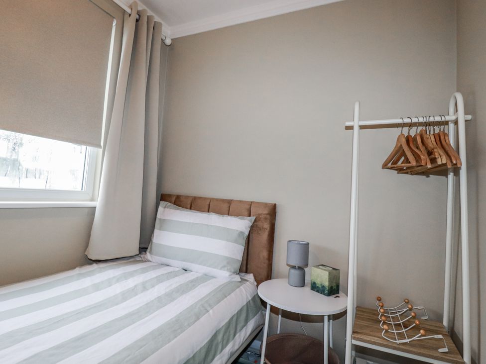 A bedroom with a bed and clothes rack at Pipers in Newquay