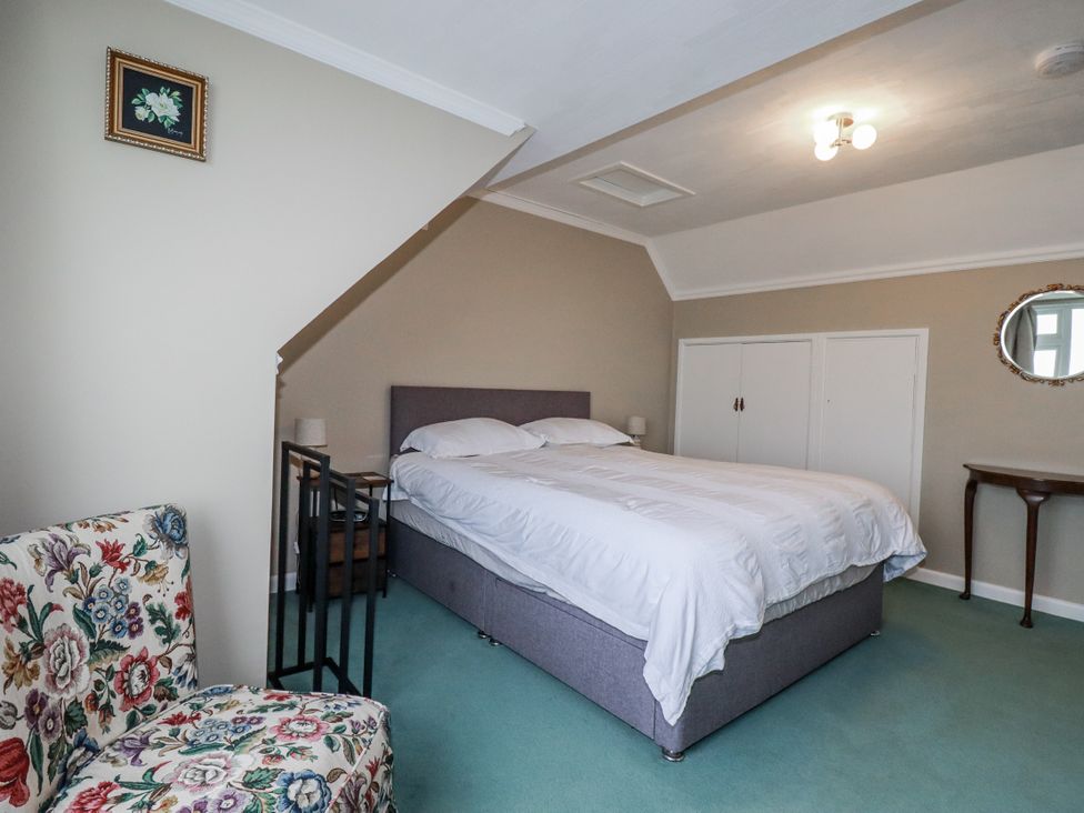 A bedroom with a bed and nightstand at Pipers in Newquay