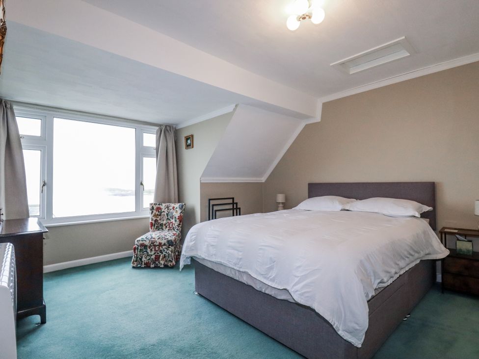 A bedroom with a bed and a chair at Pipers in Newquay