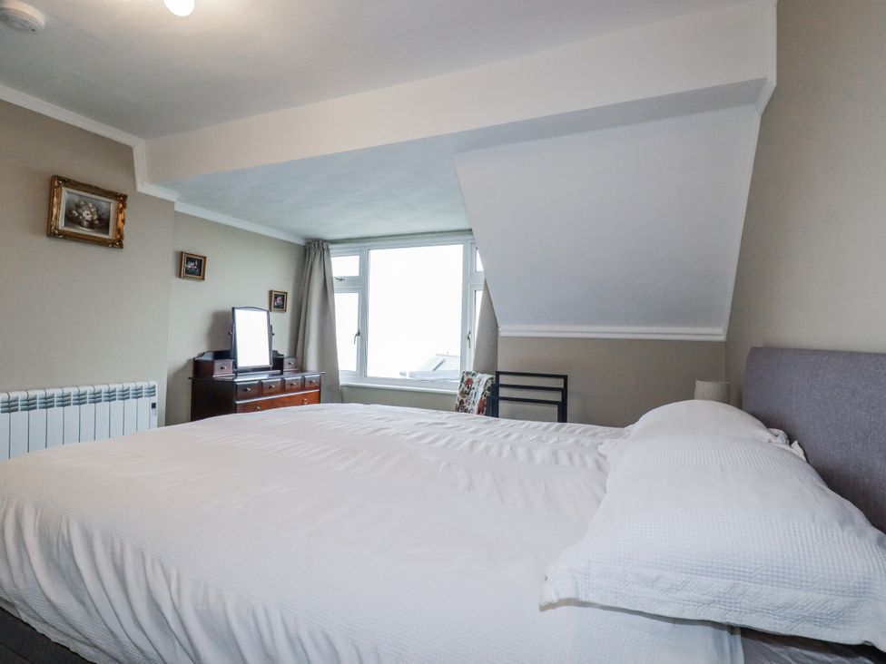 A bedroom with a bed and dresser at Pipers in Newquay