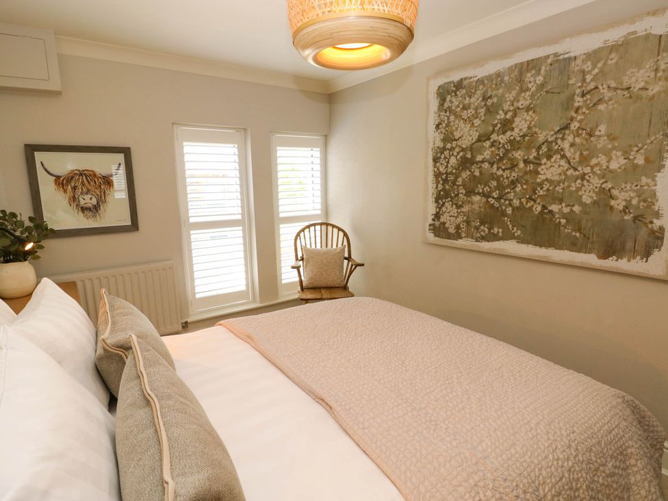 A bedroom with a bed pillows chair wall art and windows at The Loft in Ystradgynlais