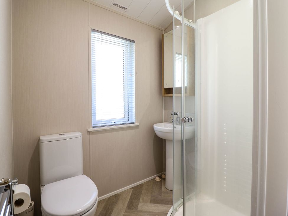 A bathroom with a toilet sink shower and window with blinds at The Owlet in Dolwen near Llanidloes