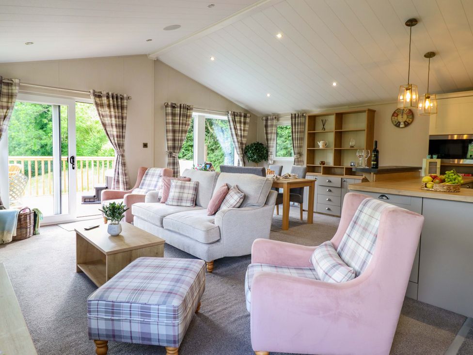 A living room with a sofa and dining area at The Owlet in Dolwen near Llanidloes