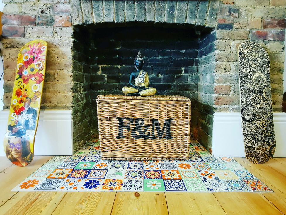 A living room with a buddha statue and skateboards at Church Retreat St. Leonards-on-Sea