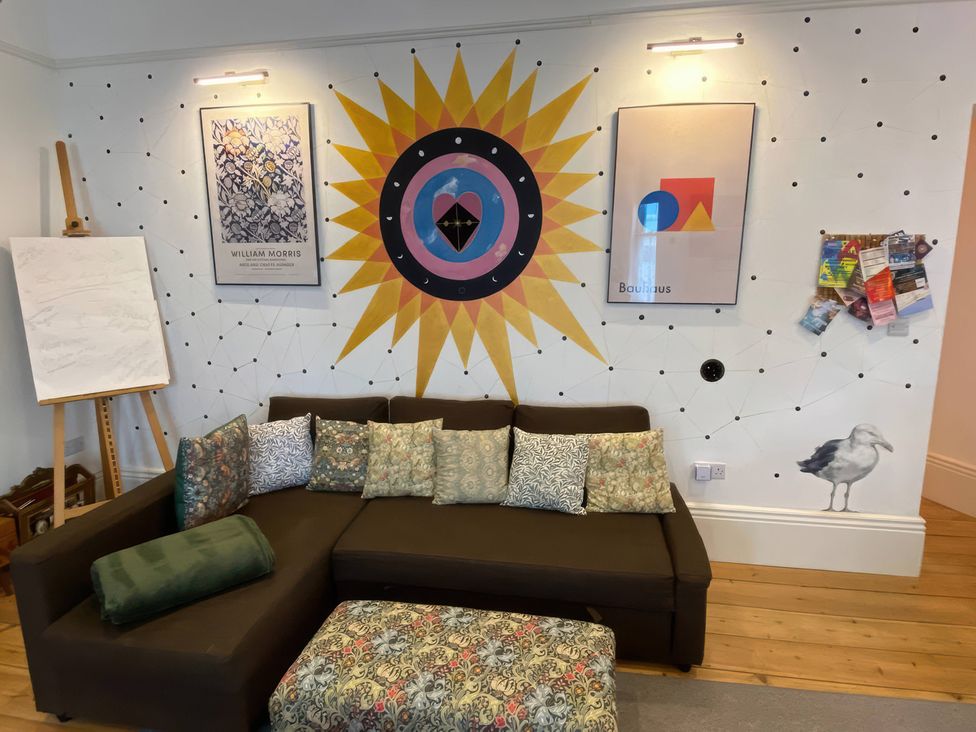 A living room with a sofa and wall art at Church Retreat in St. Leonards-on-Sea