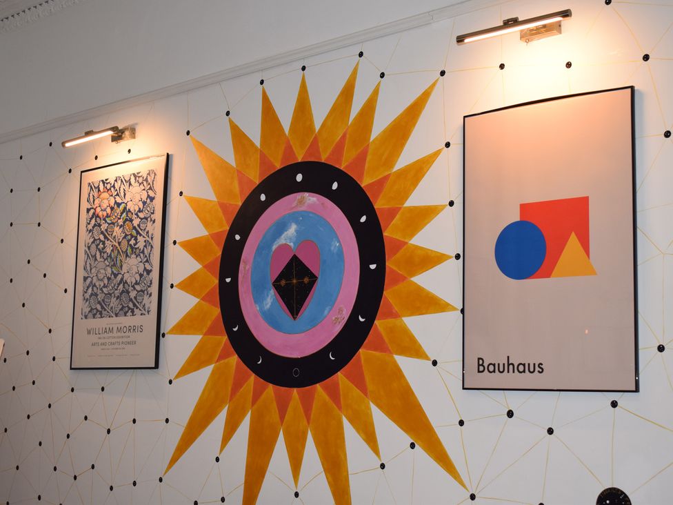 A wall with posters and art including Bauhaus and William Morris at Church Retreat in St. Leonards-on-Sea