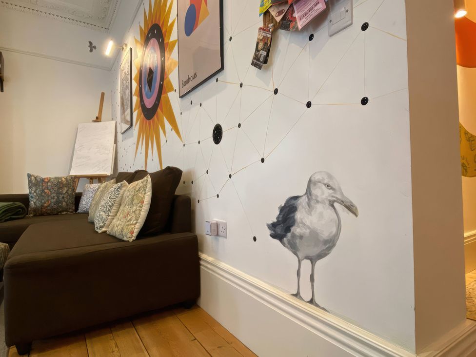 A living room with a sofa and wall artwork at Church Retreat in St. Leonards-on-Sea