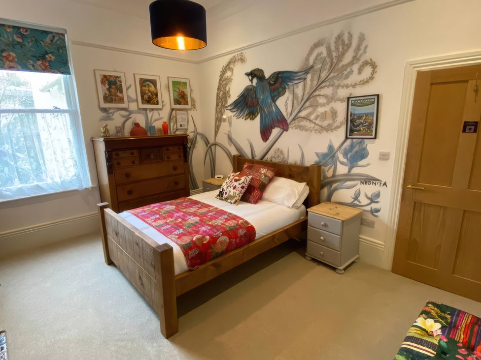 A bedroom with a bed and wall art at Church Retreat in St. Leonards-on-Sea