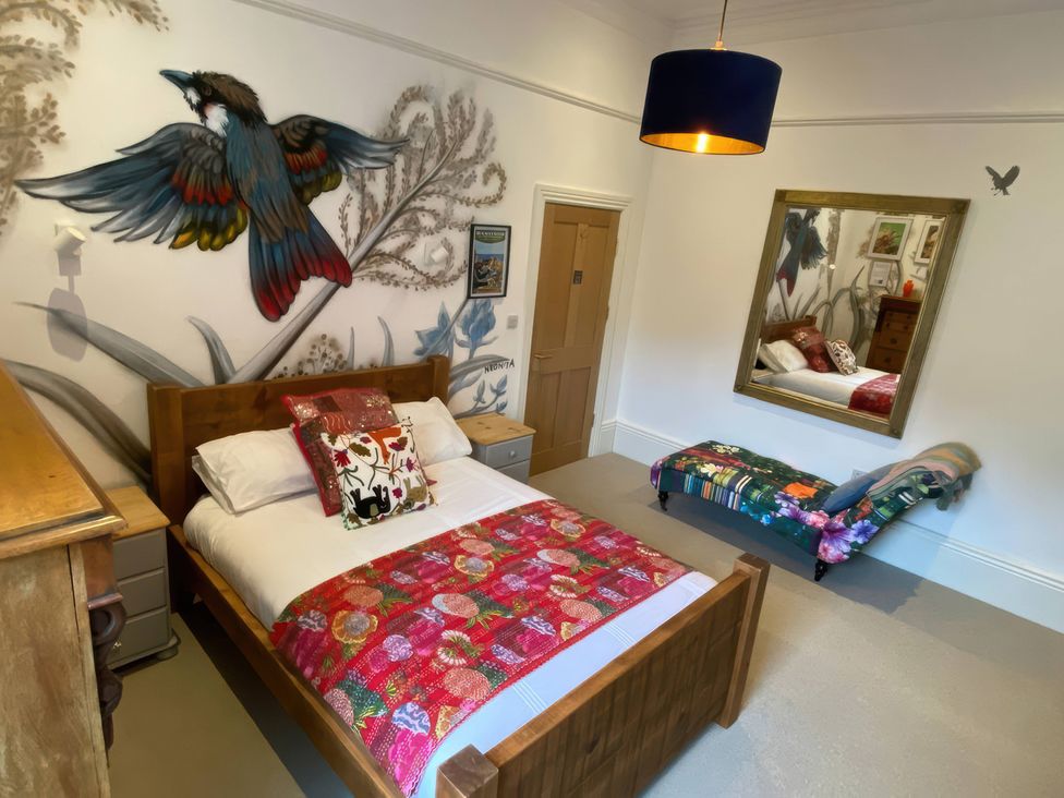 A bedroom with a bed and mirror at Church Retreat in St. Leonards-on-Sea