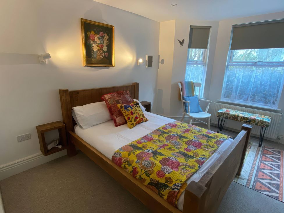 A bedroom with a bed and chair at Church Retreat in St. Leonards-on-Sea