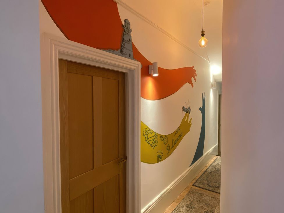 A hallway with a door and colorful wall mural at Church Retreat in St. Leonards-on-Sea