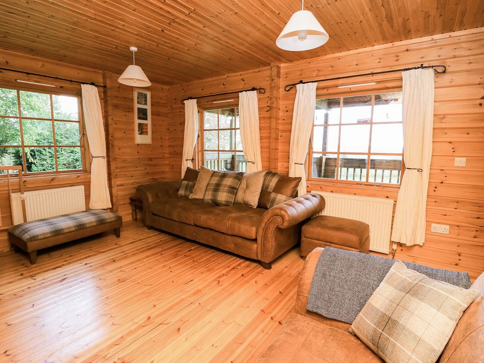 A living room with a sofa and armchair at Dan Y Coed in Beggar's Bush near Presteigne