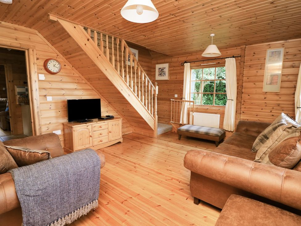 A living room with a sofa and television at Dan Y Coed in Beggar's Bush near Presteigne