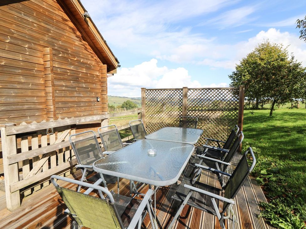 An outdoor dining area with a table and chairs at Dan Y Coed in Beggar's Bush near Presteigne