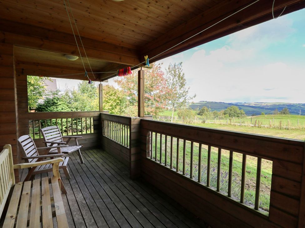 A porch with wooden flooring and chairs at Dan Y Coed near Beggar's Bush near Presteigne