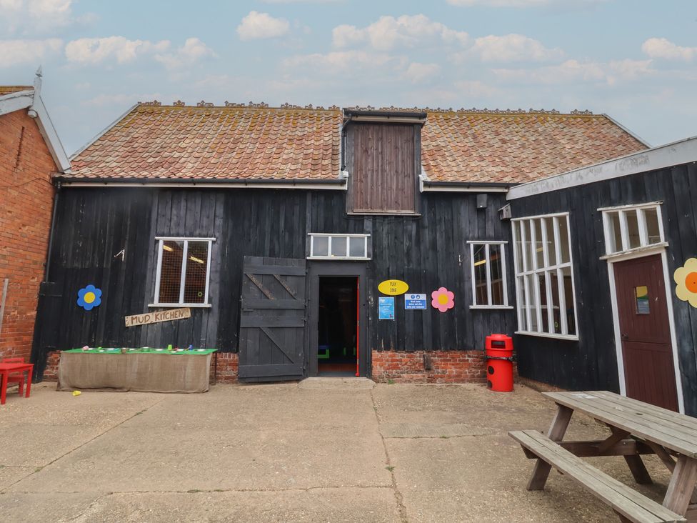 An outdoor area with a building labeled Mud Kitchen and a picnic table at Molly (Cow Shed 6) Woodbridge