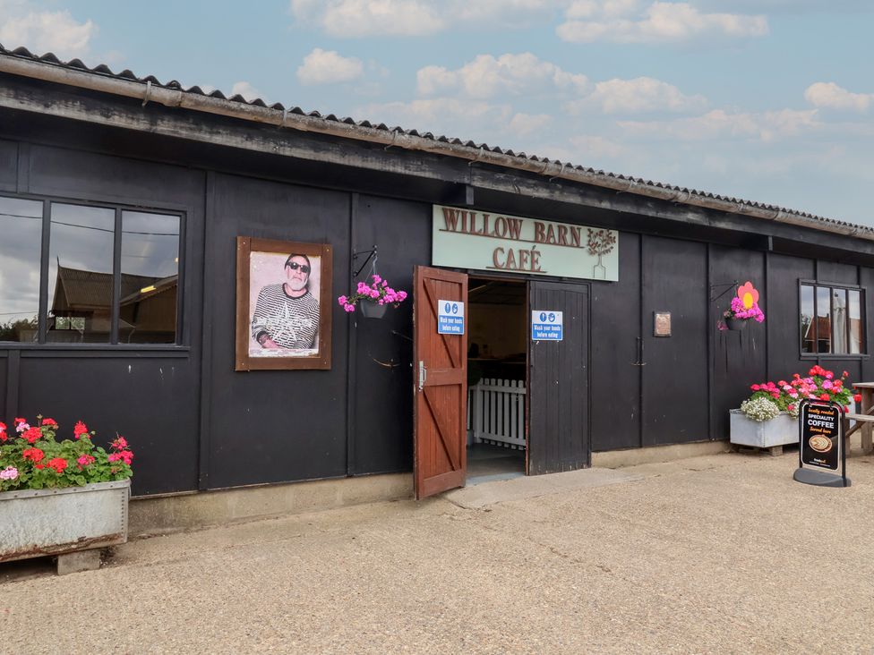 A cafe entrance with flowers and signage at Willow Barn Café in Woodbridge