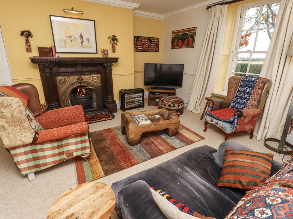 A living room with a fireplace and television at Elford Farmhouse, Seahouses