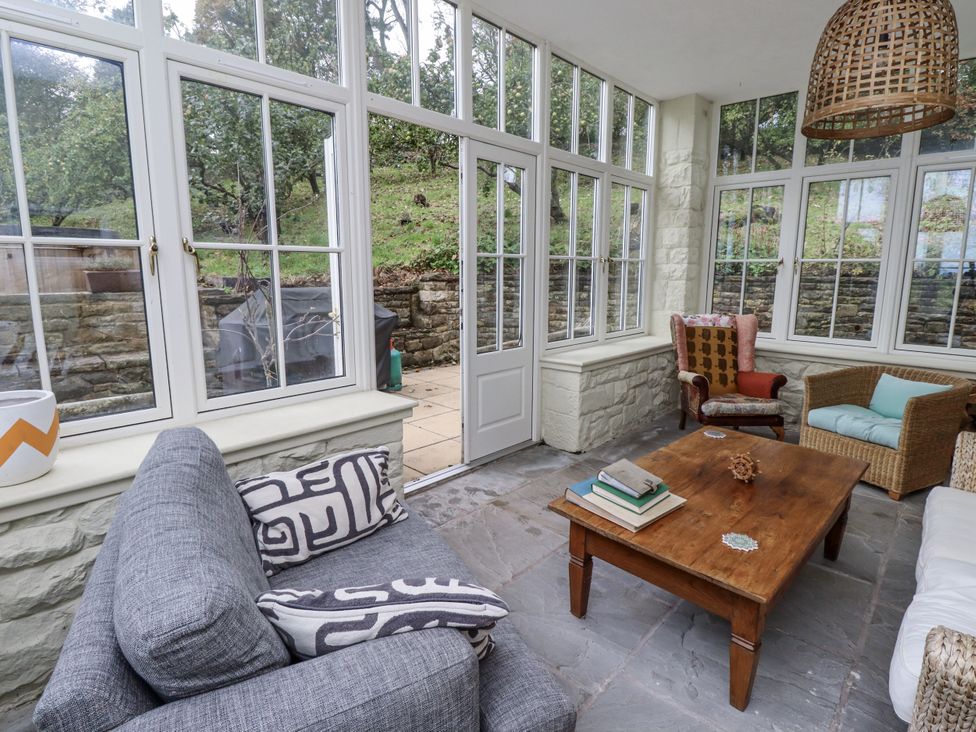 A conservatory with seating and a coffee table at Elford Farmhouse in Seahouses