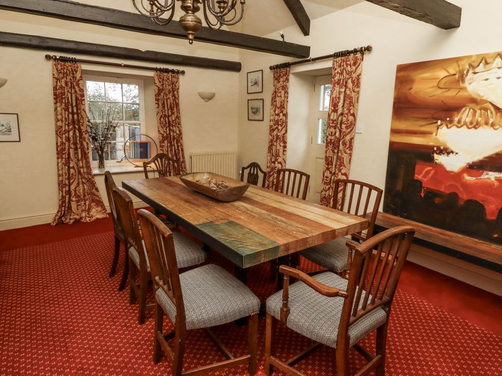 A dining room with a wooden table and chairs at Elford Farmhouse in Seahouses