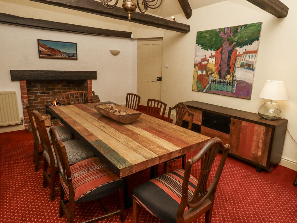 A dining room with a wooden table and chairs at Elford Farmhouse in Seahouses