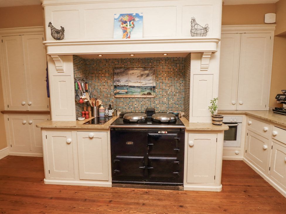 A kitchen with a cooker and utensils at Elford Farmhouse in Seahouses
