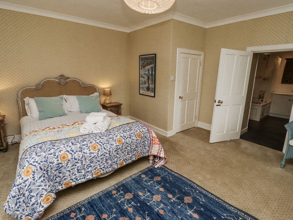 A bedroom with a bed and art on the wall at Elford Farmhouse Seahouses