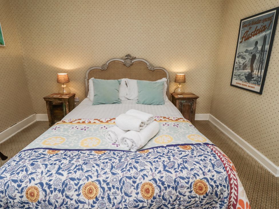 A bedroom with a bed and bedside table at Elford Farmhouse in Seahouses