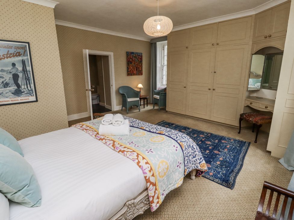 A bedroom with a bed and wardrobe at Elford Farmhouse in Seahouses
