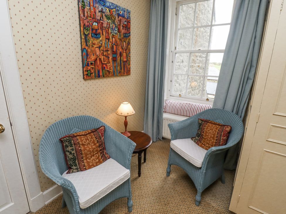 A sitting room with two chairs and a small table at Elford Farmhouse in Seahouses