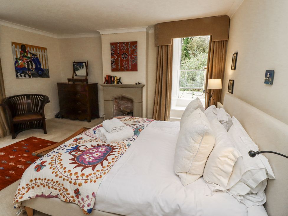 A bedroom with a bed and armchair at Elford Farmhouse in Seahouses