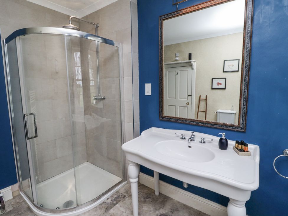 A bathroom with a shower and sink at Elford Farmhouse in Seahouses