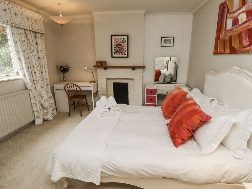 A bedroom with a bed and desk at Elford Farmhouse in Seahouses