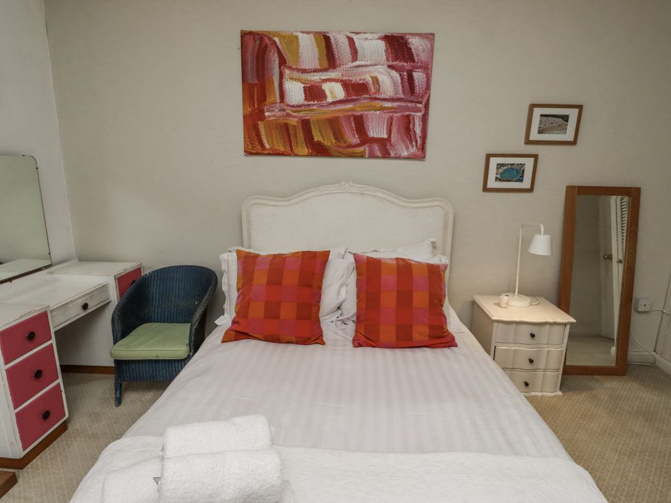 A bedroom with a bed and dresser at Elford Farmhouse in Seahouses