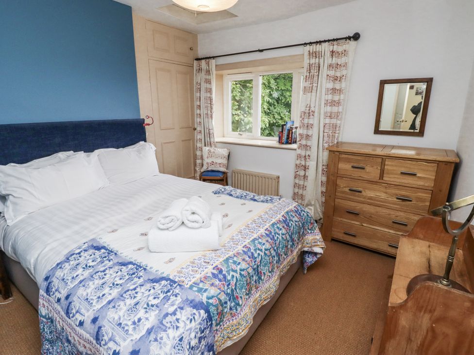 A bedroom with a bed and dresser at Elford Farmhouse Seahouses