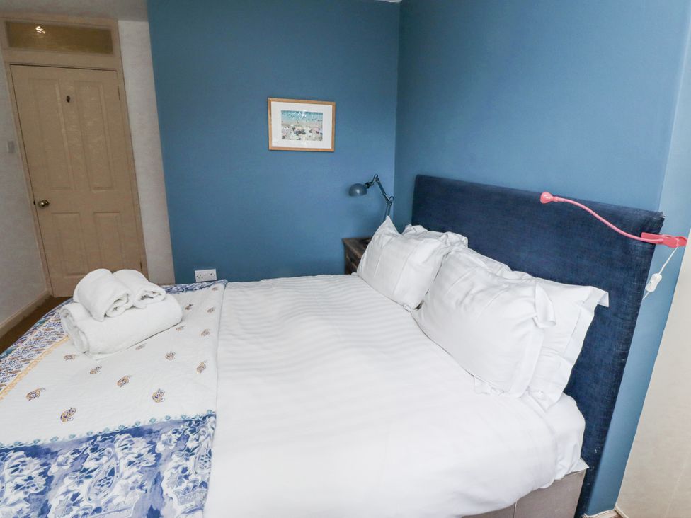 A bedroom with a bed and a lamp at Elford Farmhouse in Seahouses